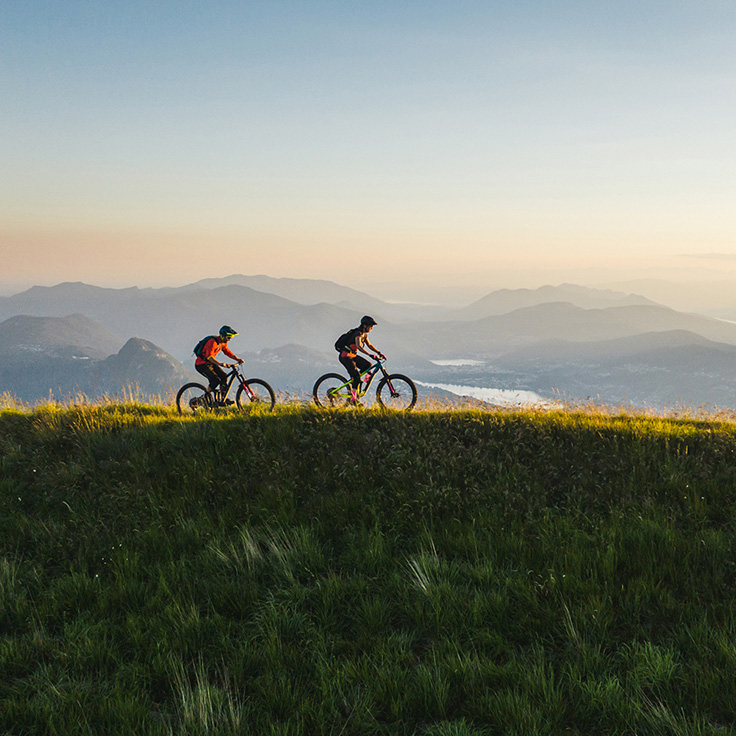 Two cyclists on grassy mountain top
