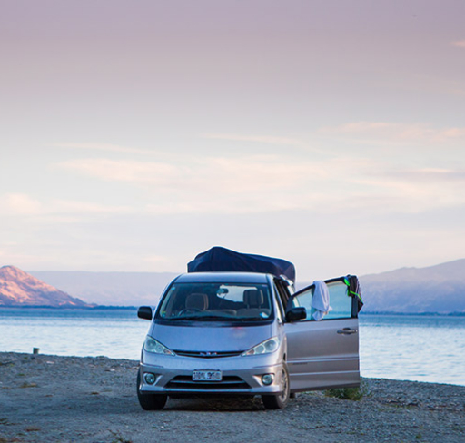 car parked by lake with door open