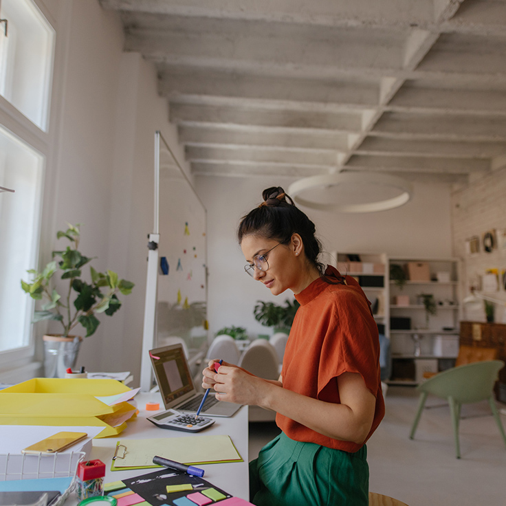 Young woman working in a light-filled warehouse style office