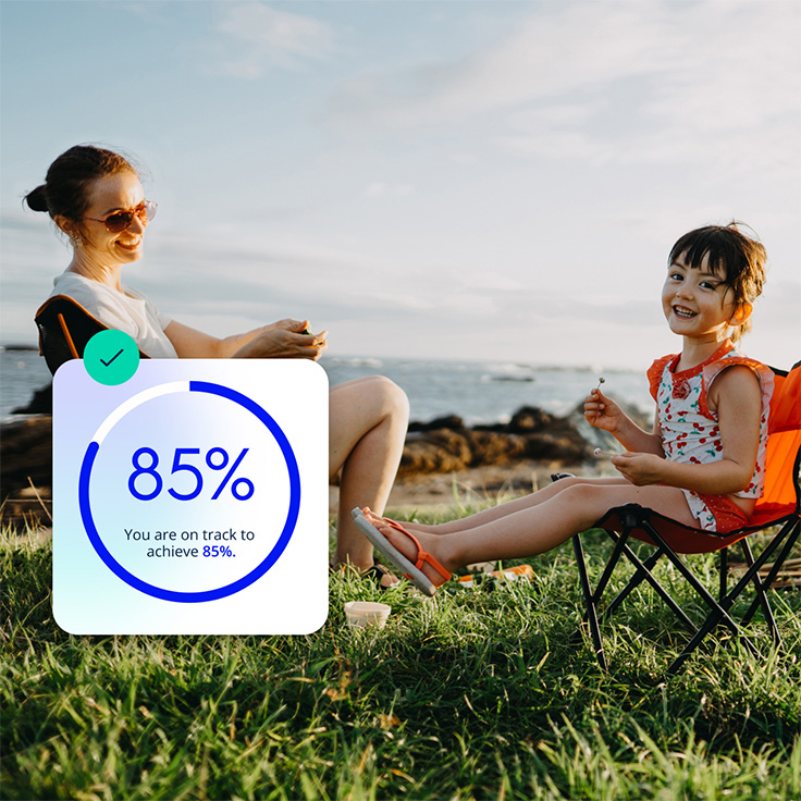 Woman and child sitting on camping chairs by ocean